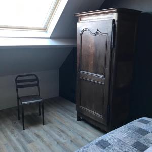 1 dormitorio con armario de madera y silla en D'n Wasschappelsen Engel Windkracht 11, en Westkapelle