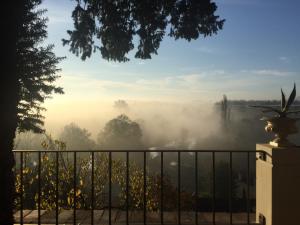 トゥアールにあるAu Petit Thouarsの塀付きの家の霧の景色