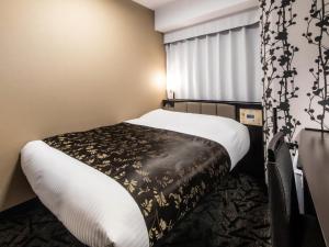 une chambre d'hôtel avec un lit et une fenêtre dans l'établissement APA Hotel SHIN-OSAKA MINAMIKATA EKIMAE, à Osaka