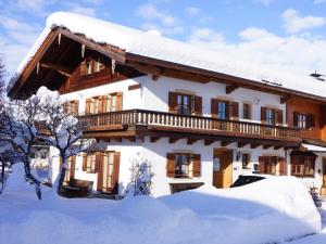 uma casa coberta de neve com uma varanda na neve em Gästehaus Gschwendtner - Chiemgau Karte em Inzell