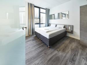 a hotel room with a bed and a mirror at Road House Hotel in Paderborn