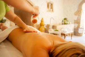 a woman getting a back massage in a room at Naturalis Bio Resort in Martano