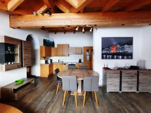 Il comprend une cuisine et une salle à manger avec une table et des chaises en bois. dans l'établissement LORA, à Fügen