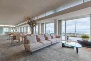 een woonkamer met een bank en een tafel bij Hotel de Baak Seaside in Noordwijk aan Zee