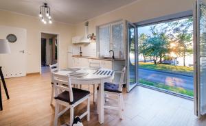 a kitchen and dining room with a table and chairs at Apartament pod Grotem z Widokiem na Jezioro, Oczy Mazur in Giżycko