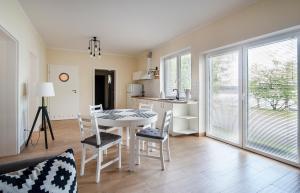 a kitchen and dining room with a table and chairs at Apartament pod Grotem z Widokiem na Jezioro, Oczy Mazur in Giżycko