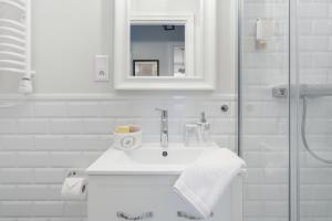 a white bathroom with a sink and a shower at Luksusowy apartament Hercena7 w sercu miasta in Wrocław