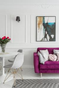 a living room with a purple couch and a table at Luksusowy apartament Hercena7 w sercu miasta in Wrocław