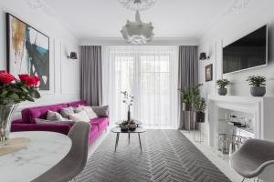 a living room with a purple couch and a table at Luksusowy apartament Hercena7 w sercu miasta in Wrocław