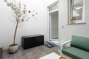 a living room with a tv and a potted tree at Casa da Porta Azul in Aveiro