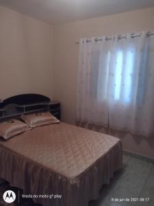 a bedroom with a bed and a window with a curtain at Estalagem Cardoso in Cunha