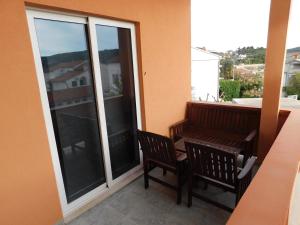 balkon z 2 krzesłami i ławką w budynku w obiekcie Apartments Del Mar w Rabie