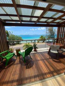 a deck with chairs and a table and a view of the ocean at Studio Moana in Bora Bora