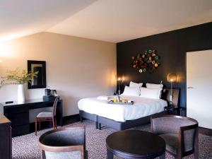 a hotel room with a bed and a table and chairs at La Citadelle Metz MGallery in Metz