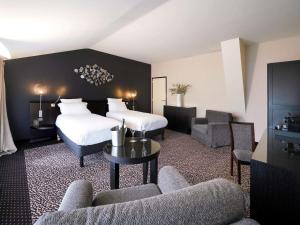 a hotel room with a bed and a couch and chairs at La Citadelle Metz MGallery in Metz