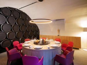 a dining room with a round table and red chairs at La Citadelle Metz MGallery in Metz