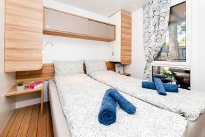 1 Schlafzimmer mit 2 Betten und blauen Kissen in der Unterkunft FantaSea Mobile Home Porton Biondi in Rovinj
