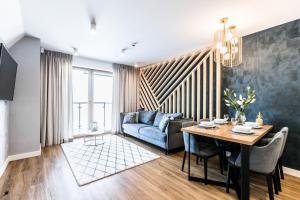 ein Wohnzimmer mit einem blauen Sofa und einem Tisch in der Unterkunft Aparthotel Prestige in Zakopane