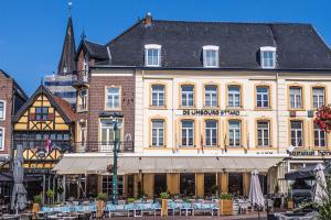 ein großes Gebäude mit Tischen und Stühlen davor in der Unterkunft Hotel De Limbourg in Sittard