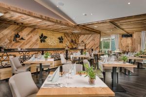 un ristorante con pareti e tavoli in legno e sedie di MONDI Hotel Tscherms a Cermes