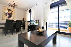 - un salon avec une table et une salle à manger dans l'établissement Estepona Port Apartment FLO, à Estepona