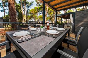 a table with plates and wine glasses on a patio at FantaSea Mobile Home Porton Biondi in Rovinj