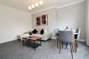 a living room with a couch and a table at Macintosh lower in Bellshill