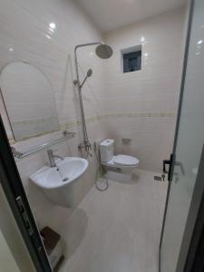 y baño con lavabo, aseo y espejo. en Motel Quốc Việt, en Bà Rịa