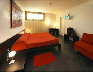 1 dormitorio con cama roja y sofá en Ca' Pozzo Inn, en Venecia