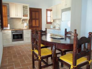 a kitchen with a wooden table and chairs in it at Patmos Houses in Patmos +40 photos