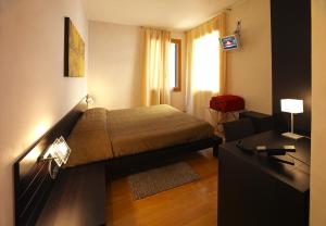 1 dormitorio con cama y escritorio. en Ca' Pozzo Inn en Venecia