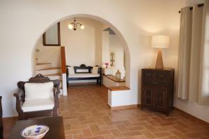 a living room with an archway and a table and chair at Patmos Houses in Patmos