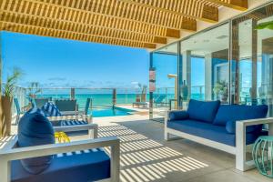 - un salon avec un canapé bleu et une vue sur l'océan dans l'établissement Hotel Água de Coco, à Maceió