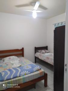 sypialnia z 2 łóżkami i wentylatorem sufitowym w obiekcie Casa 3 quartos com Piscina em Itatiaia w mieście Itatiaia
