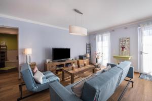 ein Wohnzimmer mit einem Sofa und einem TV in der Unterkunft Ferienwohnung Lausbub in Otterfing