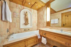 ein Badezimmer mit einer Badewanne und einem Waschbecken in der Unterkunft Parkhotel Wallgau in Wallgau