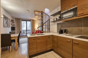 una cocina con armarios de madera y una mesa con comedor. en Apartment Petit Dru, en Chamonix-Mont-Blanc