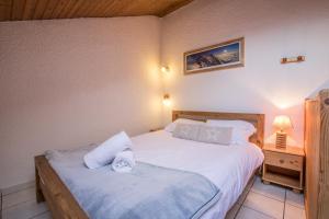 1 dormitorio con 2 camas con sábanas blancas y lámpara en Apartment Petit Dru, en Chamonix-Mont-Blanc
