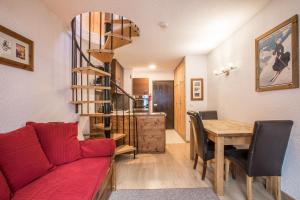 sala de estar con sofá rojo y mesa de madera en Apartment Petit Dru, en Chamonix-Mont-Blanc