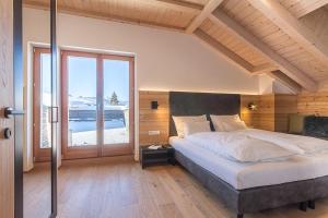 sypialnia z łóżkiem i dużym oknem w obiekcie Bellavista Apartment w mieście Dobbiaco