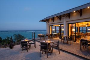 um restaurante com mesas e cadeiras num deque em Constance Tekoma em Rodrigues Island