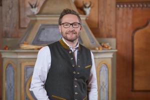 a man wearing glasses and a vest at Parkhotel Wallgau in Wallgau