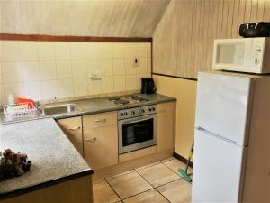a kitchen with a white refrigerator and a sink at Zur Alten Mine in Graskop