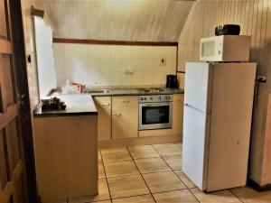a kitchen with a white refrigerator and a stove at Zur Alten Mine in Graskop