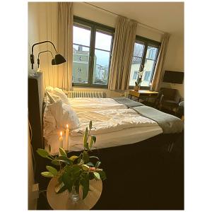 Un dormitorio con una cama y una mesa con una planta en Hotell Värend en Växjö