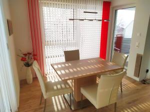 comedor con mesa de madera y sillas blancas en Alpenblick Apartment Gastein - inklusive Eintritt Alpentherme, en Bad Hofgastein