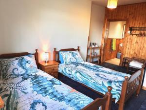 a bedroom with two beds and a table with a lamp at Windhaven Camping and B&B in Thurso