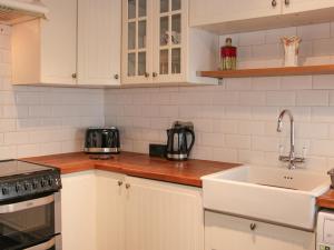 a kitchen with white cabinets and a sink at The Saltbox in Bridgnorth