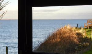 a view of the ocean from a window at Windhaven Camping and B&B in Thurso