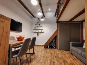 a dining room and living room with a table and chairs at Colfly Studios in Braşov